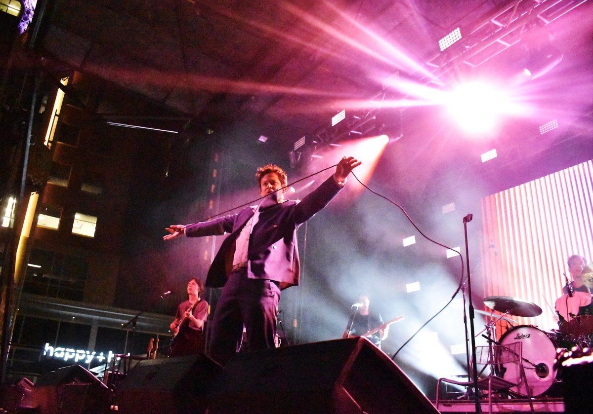 Mike Hadreas with arms extended and a a taught microphone cord between them.